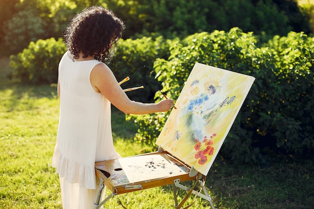 Hermosa mujer adulta dibujo en un campo de verano