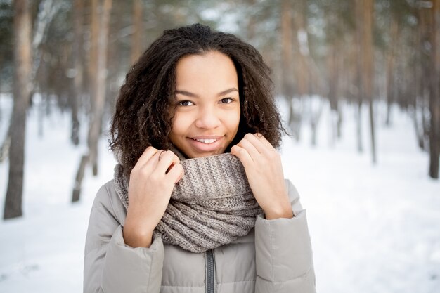 Hermosa mujer africana conmovedora bufanda en invierno