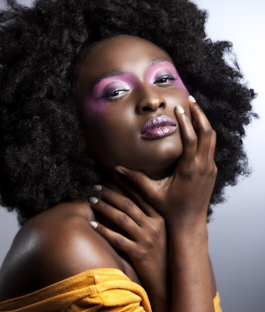 Hermosa mujer africana con gran afro rizado y flores en el pelo