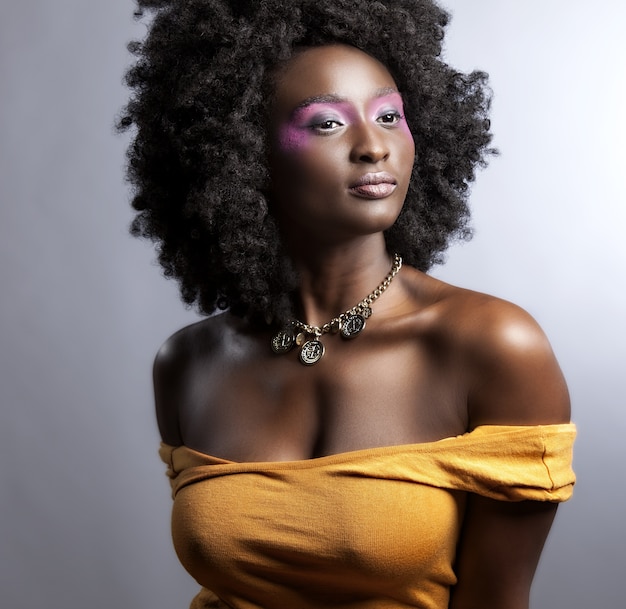 Hermosa mujer africana con gran afro rizado y flores en el pelo