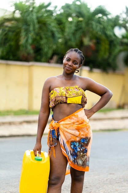 Hermosa mujer africana sosteniendo un recipiente de agua