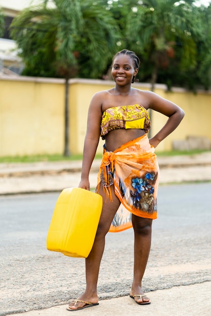 Hermosa mujer africana sosteniendo un recipiente de agua