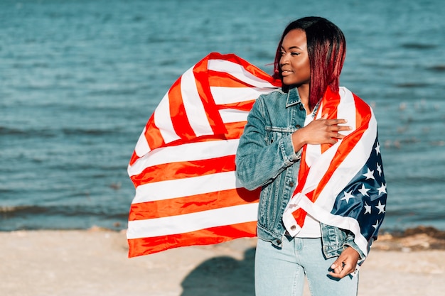 Hermosa mujer afroamericana con ondeando bandera americana