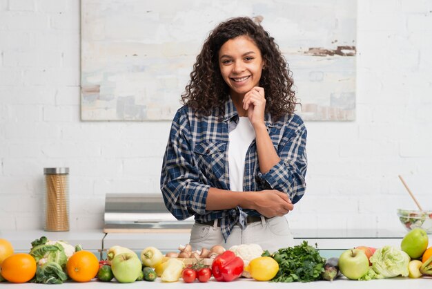 Hermosa mujer afroamericana posando junto a las verduras