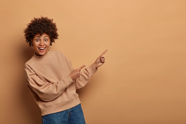 Hermosa mujer afroamericana en suéter beige