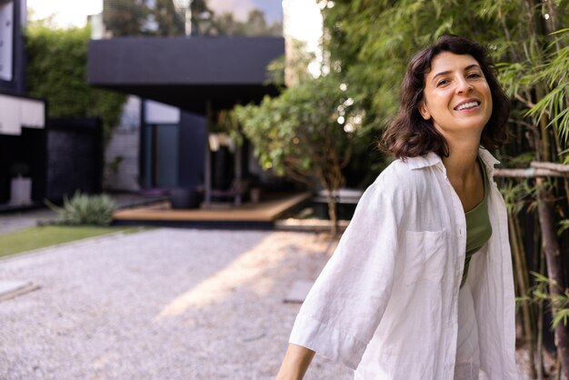 Hermosa mujer al aire libre con camisa blanca mirando a la cámara