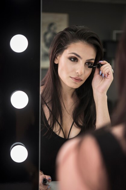 Hermosa mujer aplicando maquillaje