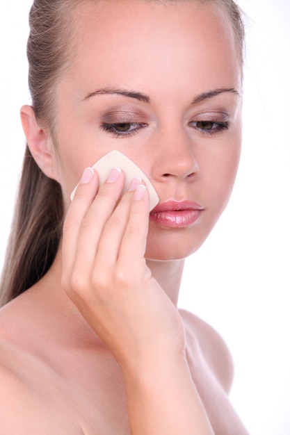 Hermosa mujer aplicando polvo en la cara