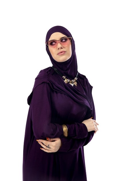 Hermosa mujer árabe posando en elegante hijab aislado sobre fondo de estudio. Concepto de moda