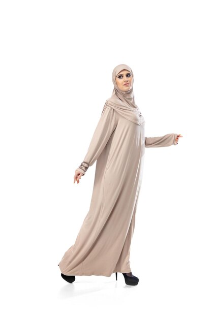 Hermosa mujer árabe posando en elegante hijab aislado sobre fondo de estudio. Concepto de moda