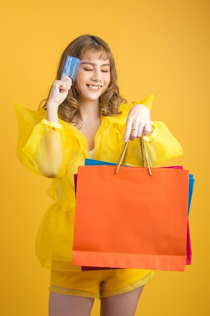 Hermosa mujer asiática con bolsa y tarjeta de crédito en mano