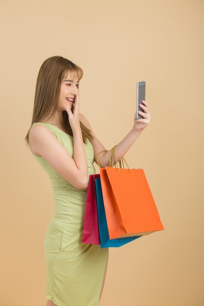 Hermosa mujer asiática con bolsa y tarjeta de crédito en mano