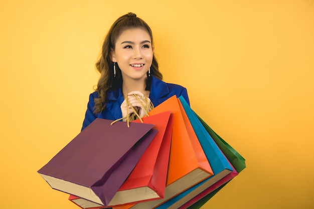 Hermosa mujer asiática con bolsa y tarjeta de crédito en mano