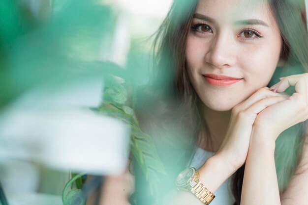 Hermosa mujer asiática bonita sonrisa y piel sana con retrato de árbol de hoja verde