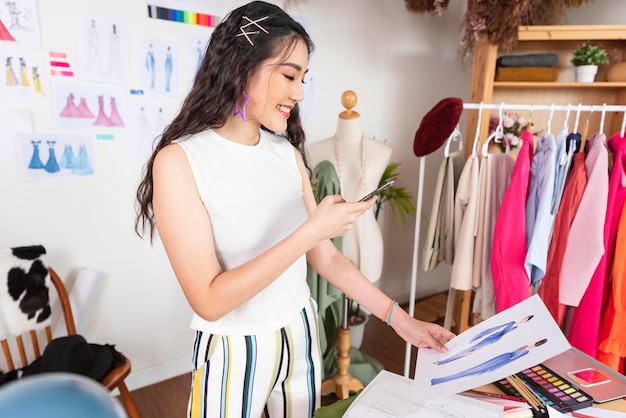 Hermosa mujer asiática diseñadora de moda trabajando para tomar una foto en el estudio de la oficina