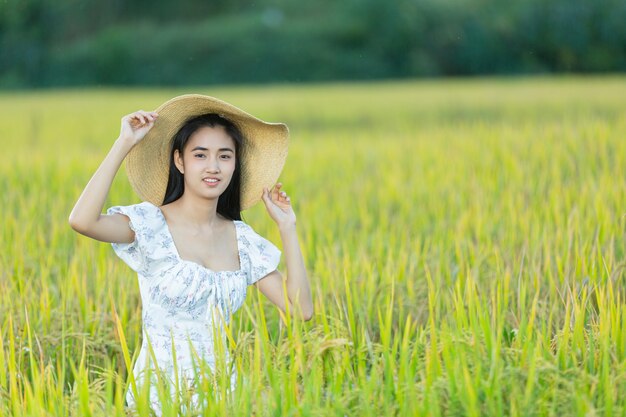 Hermosa mujer asiática disfrutando en el campo de arroz
