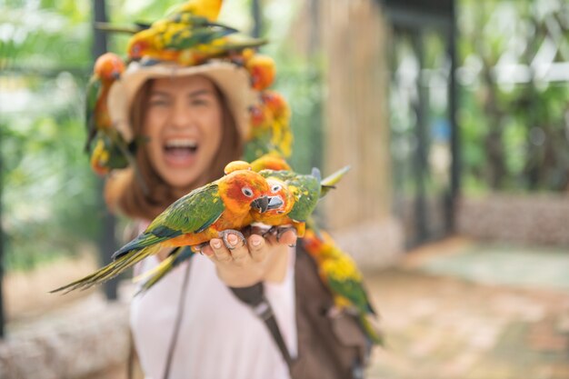 Hermosa mujer asiática disfrutando con el pájaro del amor en la mano