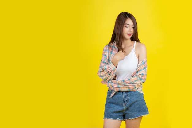 Hermosa mujer asiática en pared amarilla