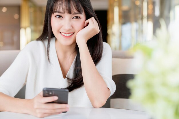 Hermosa mujer asiática retrato de pelo largo y negro suéter blanco con sonrisa de felicidad y pensamiento positivo