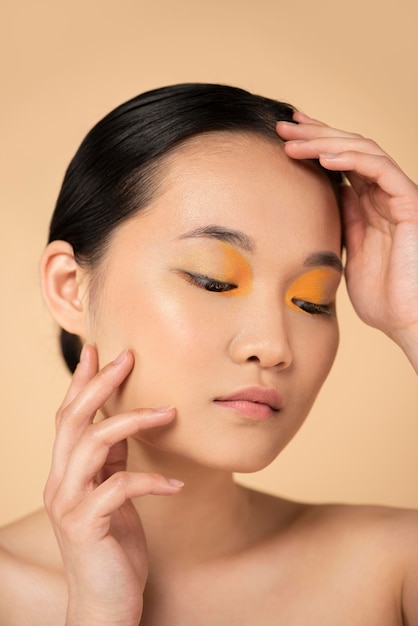Hermosa mujer asiática con sombra de ojos naranja