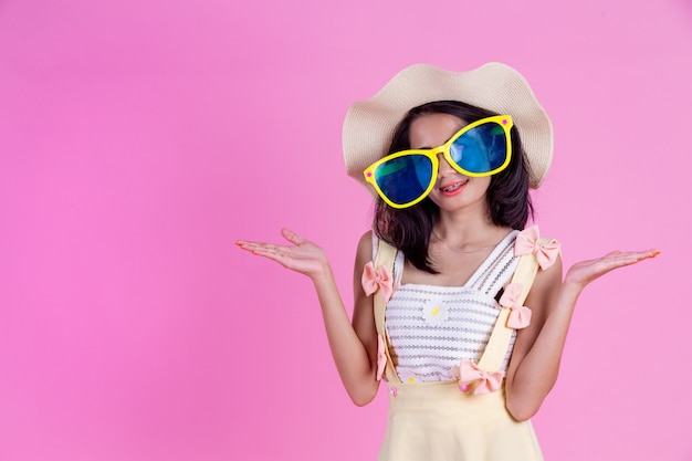 Foto gratuita una hermosa mujer asiática con un sombrero y grandes gafas con una rosa.