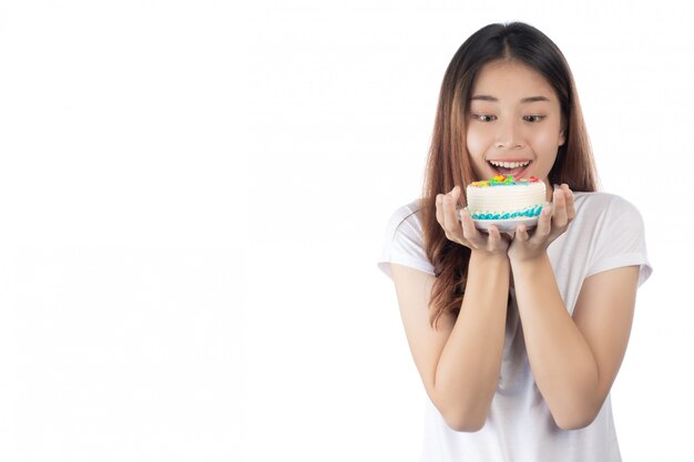 Hermosa mujer asiática con una sonrisa feliz sosteniendo un pastel en la mano
