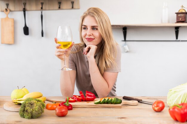 Hermosa mujer bebiendo y comiendo verduras