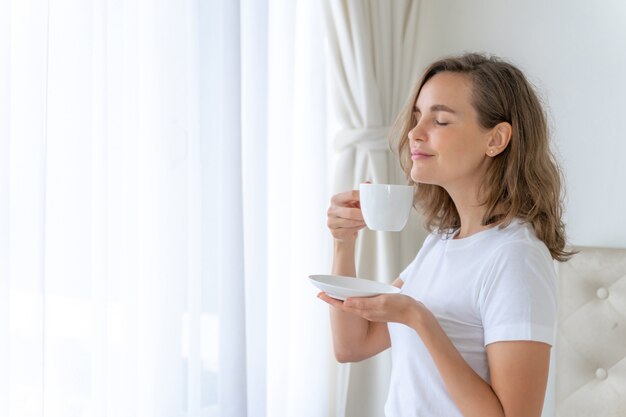 Hermosa mujer de belleza linda chica se siente feliz tomando café en la mañana