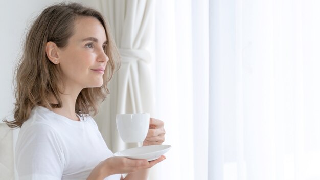 Hermosa mujer de belleza linda chica se siente feliz tomando café en la mañana