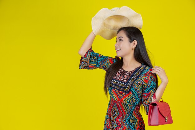 Foto gratuita hermosa mujer con una bolsa en el amarillo