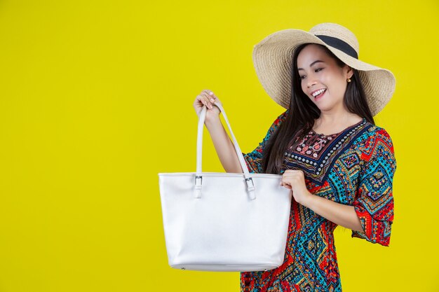 Hermosa mujer con una bolsa en el amarillo