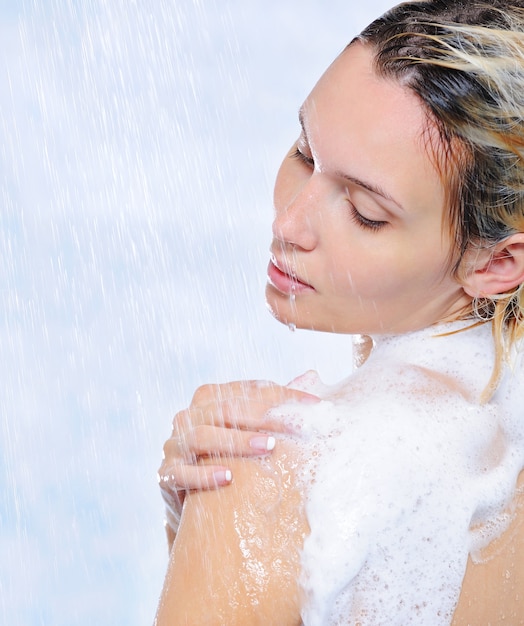 Foto gratuita hermosa mujer bonita de pie bajo corrientes de agua - primer plano