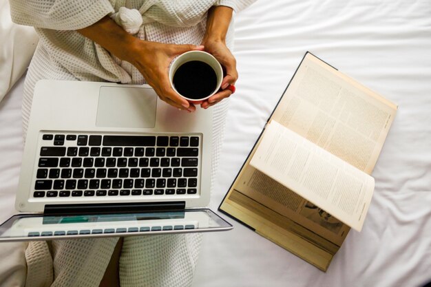 Hermosa mujer buena taza de ordenador de la cama