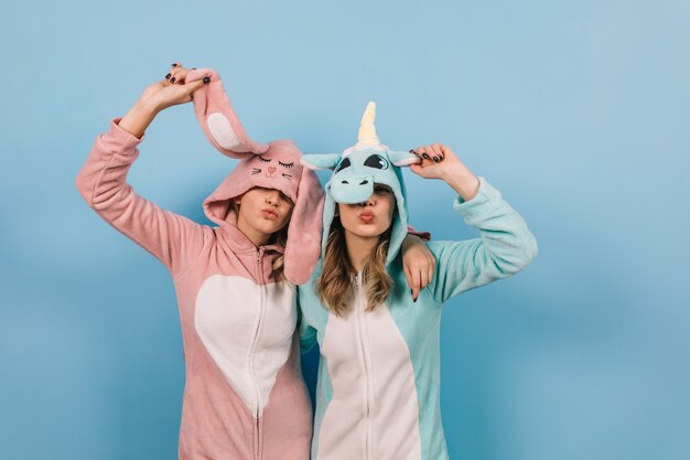 Hermosa mujer en bunny kigurumi posando con un amigo