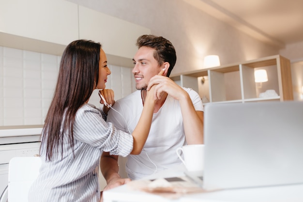 Hermosa mujer con cabello largo y negro escuchando la canción favorita con su novio en fin de semana