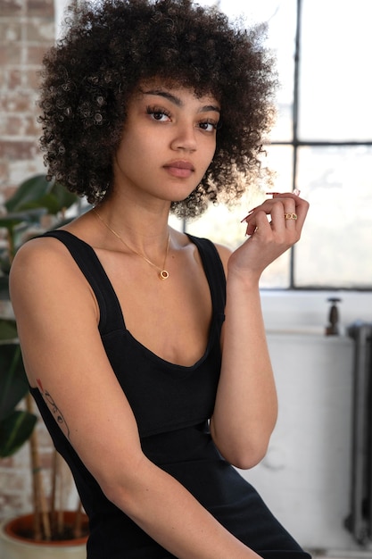 Foto gratuita hermosa mujer con cabello rizado posando de manera segura