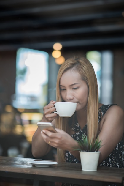 Hermosa mujer en un café tomando café