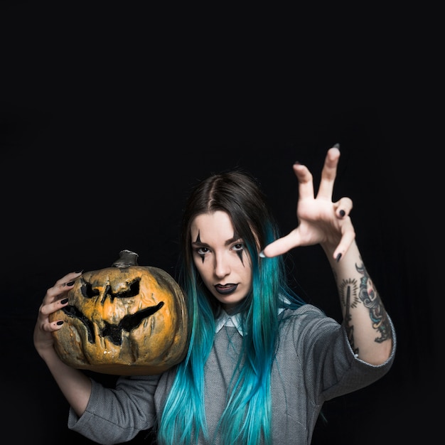 Hermosa mujer con calabaza de Halloween