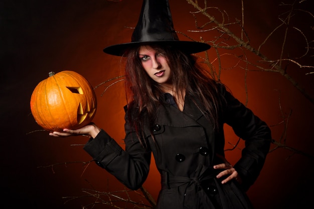 Hermosa mujer con una calabaza en las manos