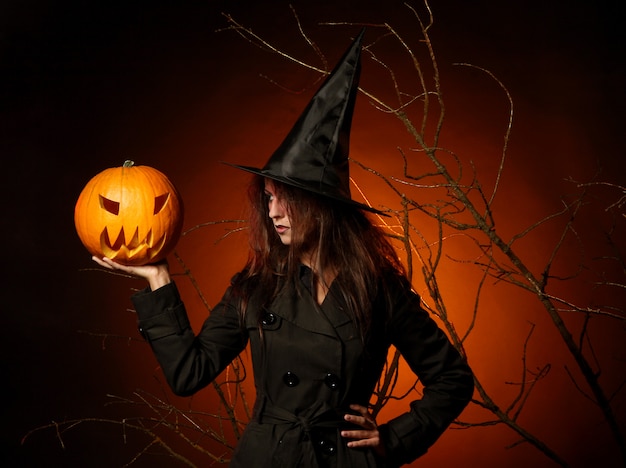 Hermosa mujer con una calabaza en las manos