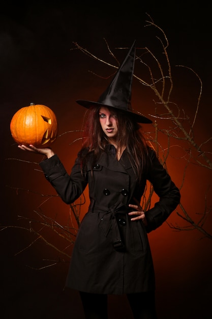 Hermosa mujer con una calabaza en las manos