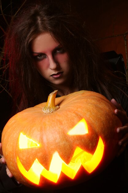 Hermosa mujer con una calabaza en las manos