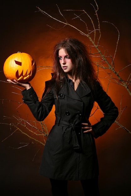 Hermosa mujer con una calabaza en las manos