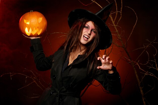 Hermosa mujer con una calabaza en las manos