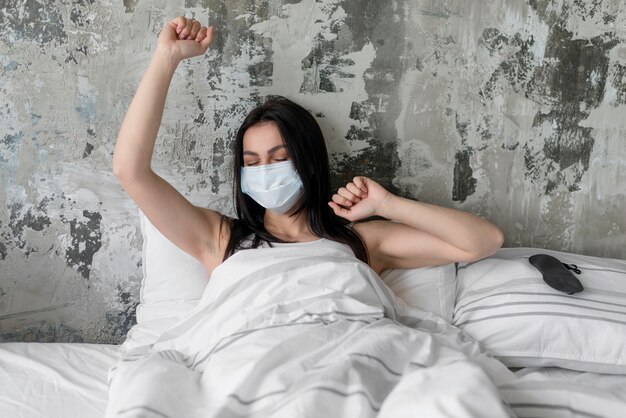 Foto gratuita hermosa mujer en la cama con mascarilla