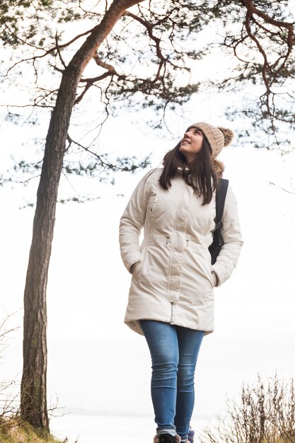 Hermosa mujer caminando cerca de un árbol