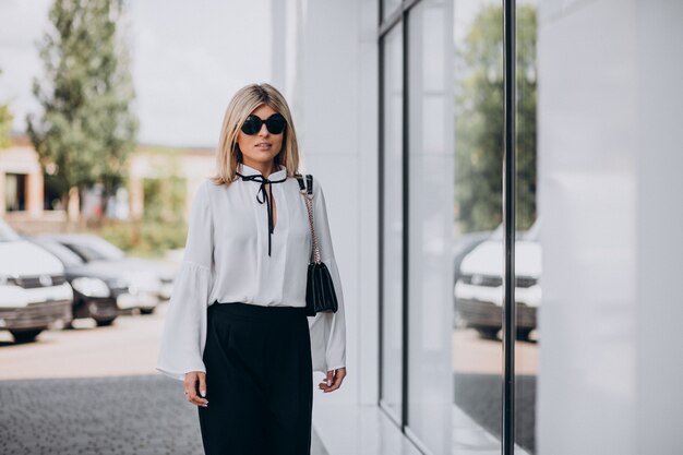 Hermosa mujer en camisa blanca fuera de la calle