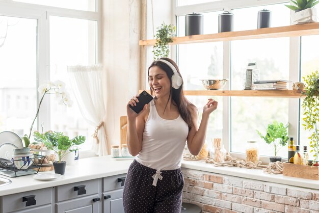 Hermosa mujer cantando en la cocina