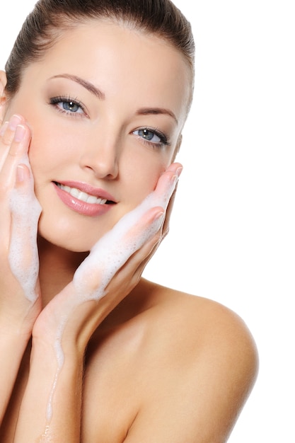 Foto gratuita hermosa mujer caucásica lavando su rostro de salud de belleza con espuma en sus manos