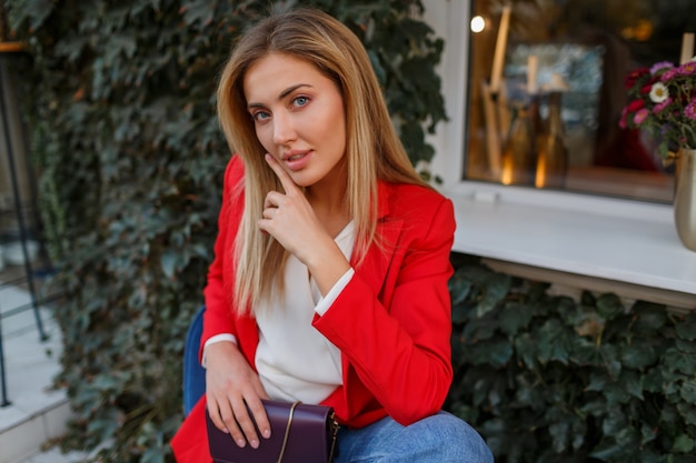 Hermosa mujer de chaqueta roja descansando en street cafe